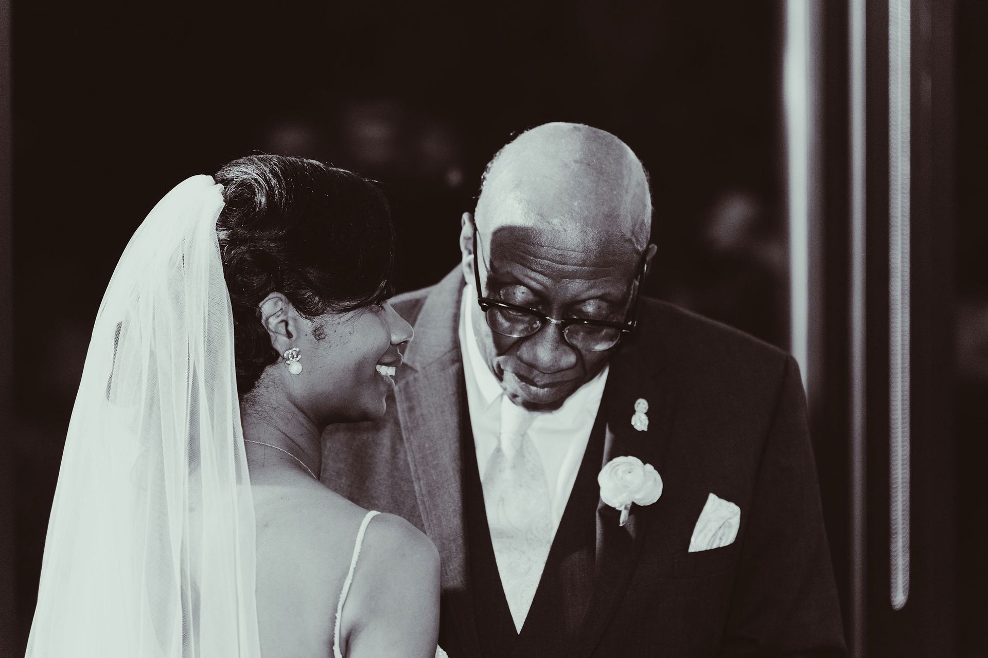 A black and white photo of a bride and her father