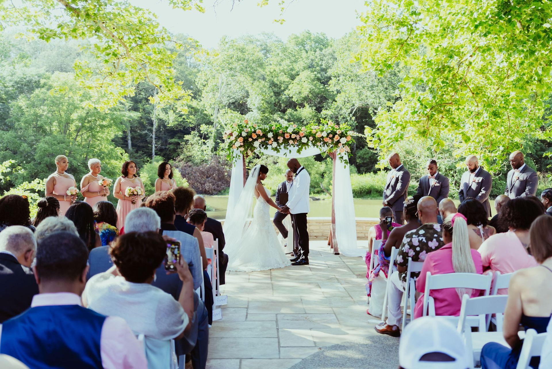 A bride and groom are getting married in front of a crowd of people.