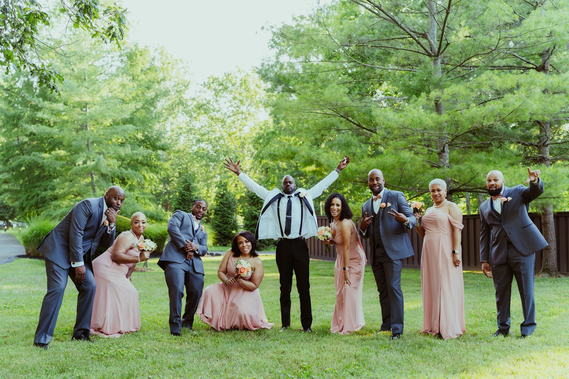 The bride and groom are posing for a picture with their wedding party.