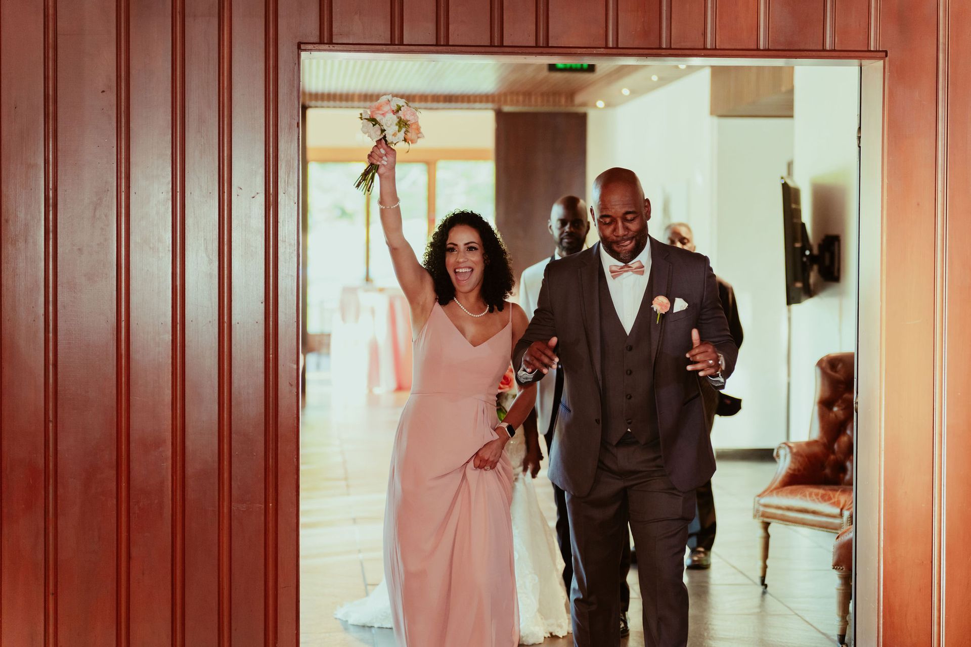 A bride and groom are walking through a doorway.