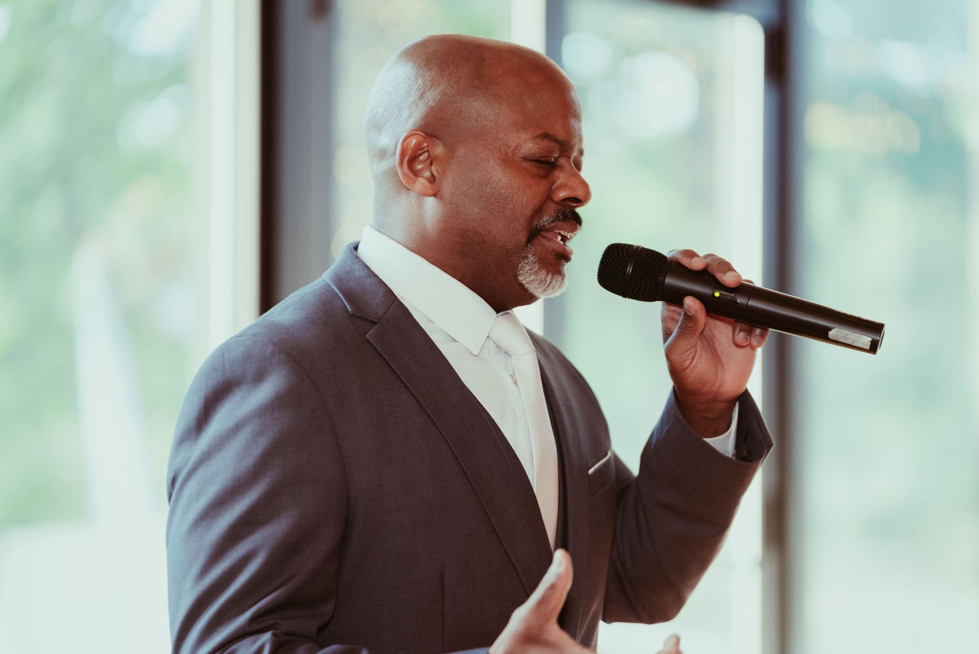 A man in a suit is singing into a microphone.