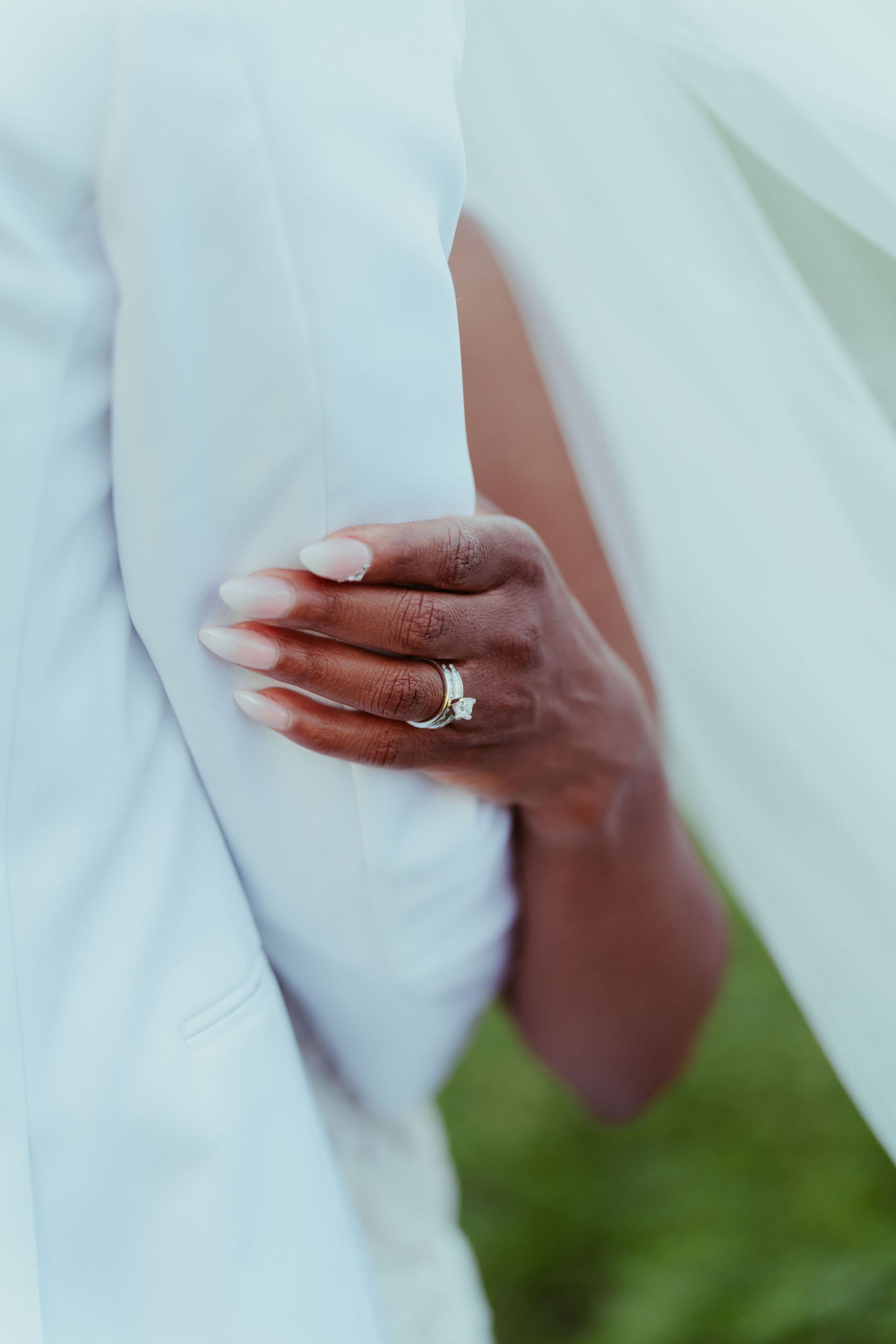 A close up of a woman 's hand with a wedding ring on it.