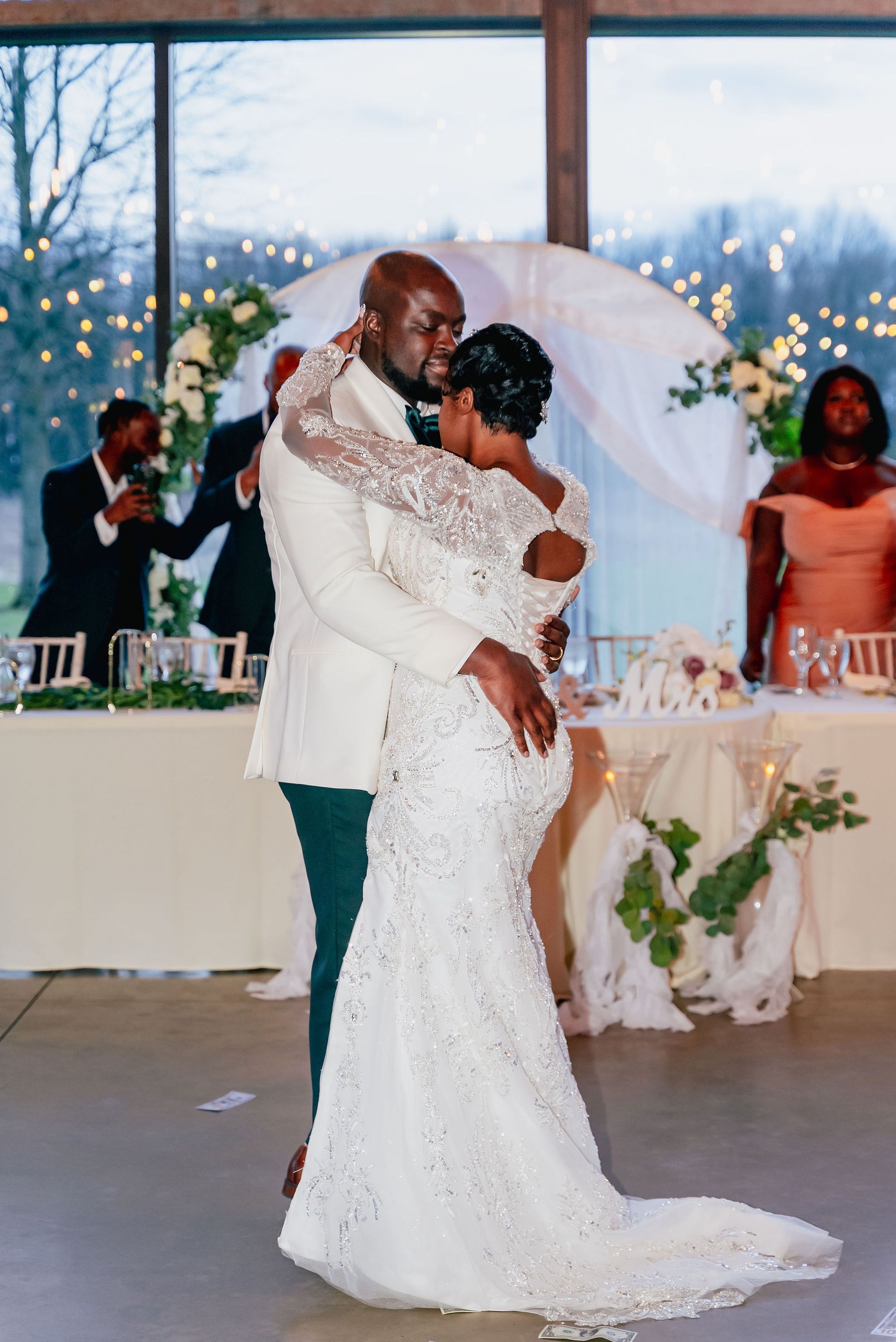 A bride and groom are dancing at their wedding reception.
