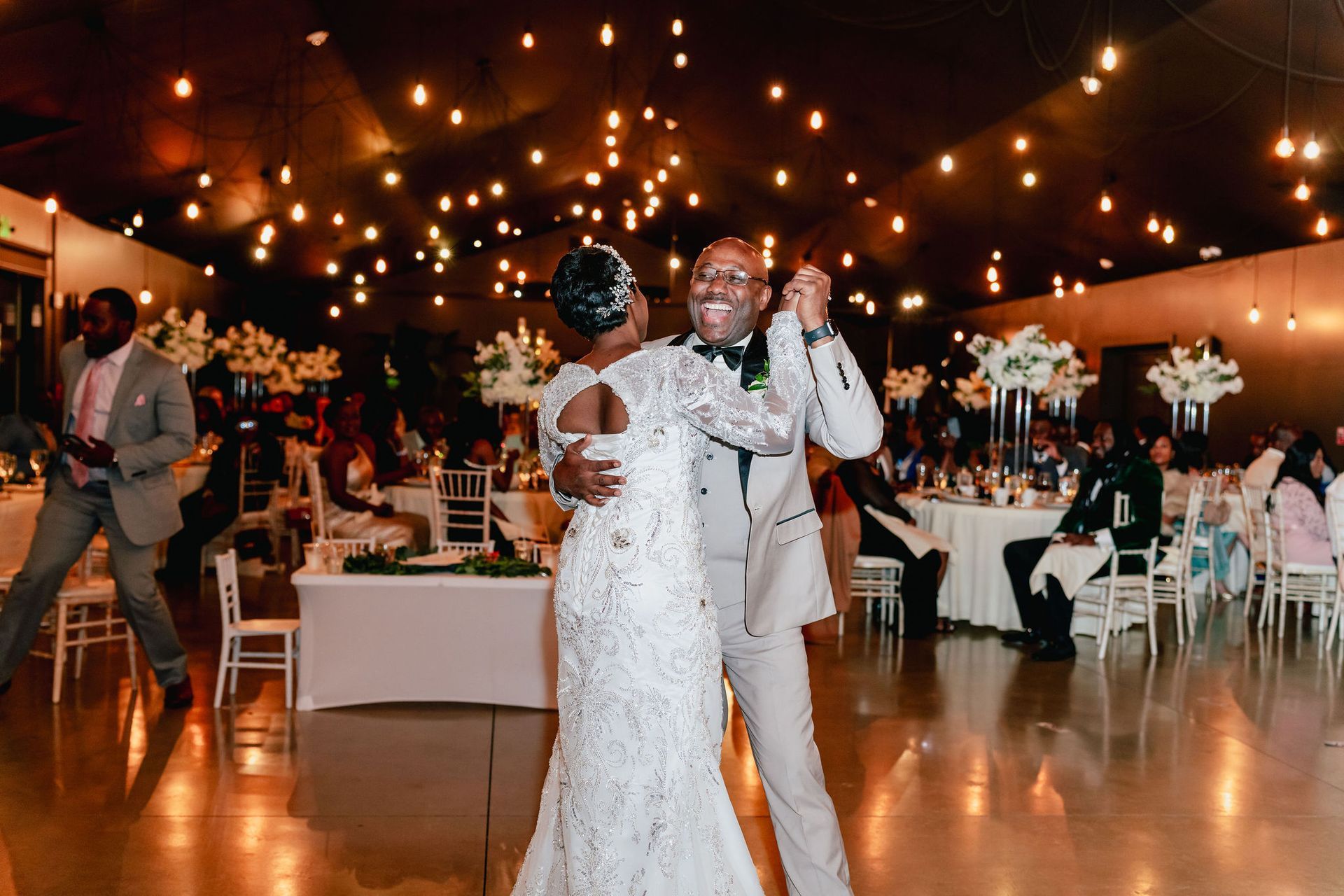 A bride and groom are dancing at their wedding reception.