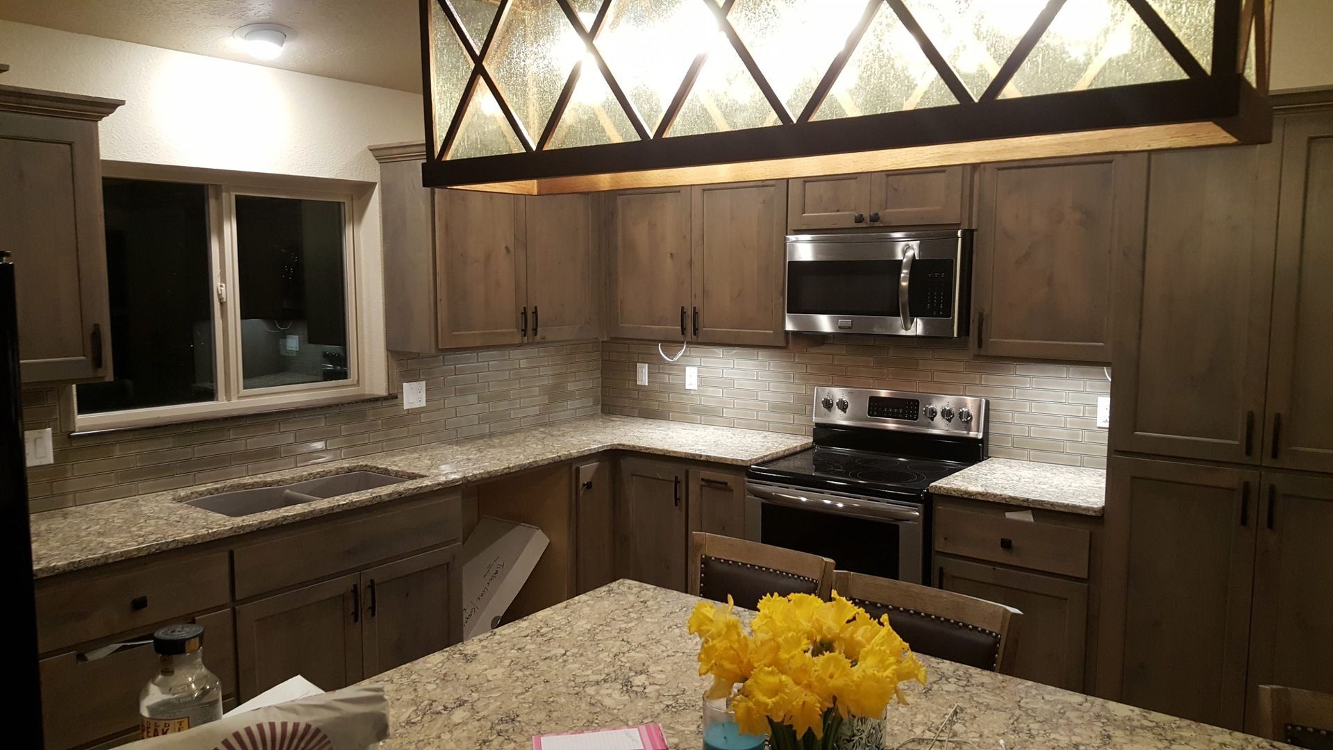 Kitchen with light brown cabinets, granite countertops, and stainless steel appliances.