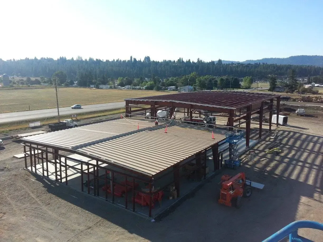 Pre-engineered steel building under construction on an open North Idaho site