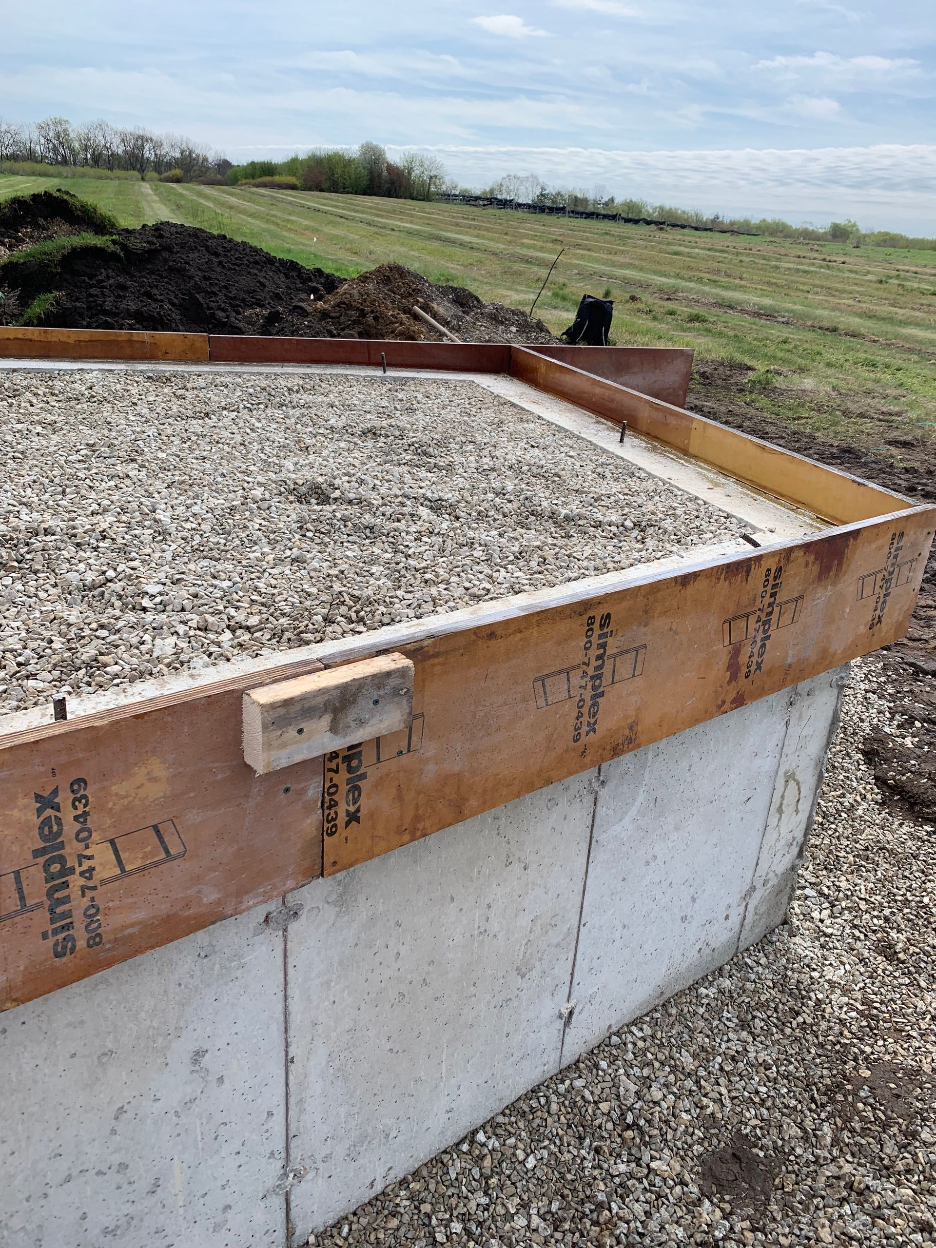A concrete foundation is being built in a field.