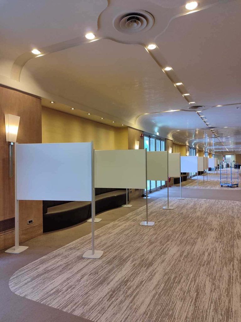 Corridoio conferenze vuoto con pareti divisorie bianche autoportanti e luci a soffitto.