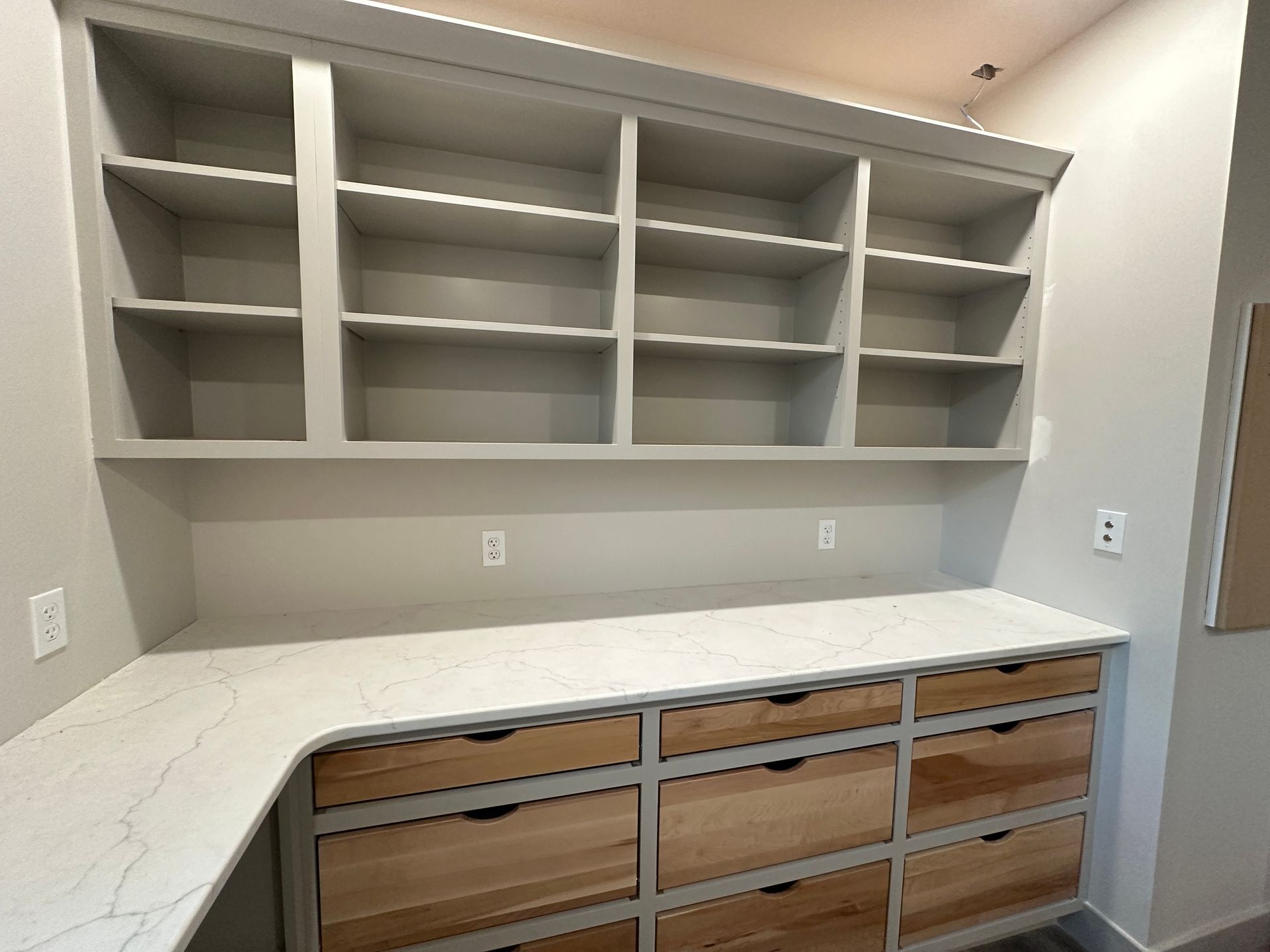 Built-in shelving and drawers with a countertop. The shelves are above the countertop, which is above the drawers.