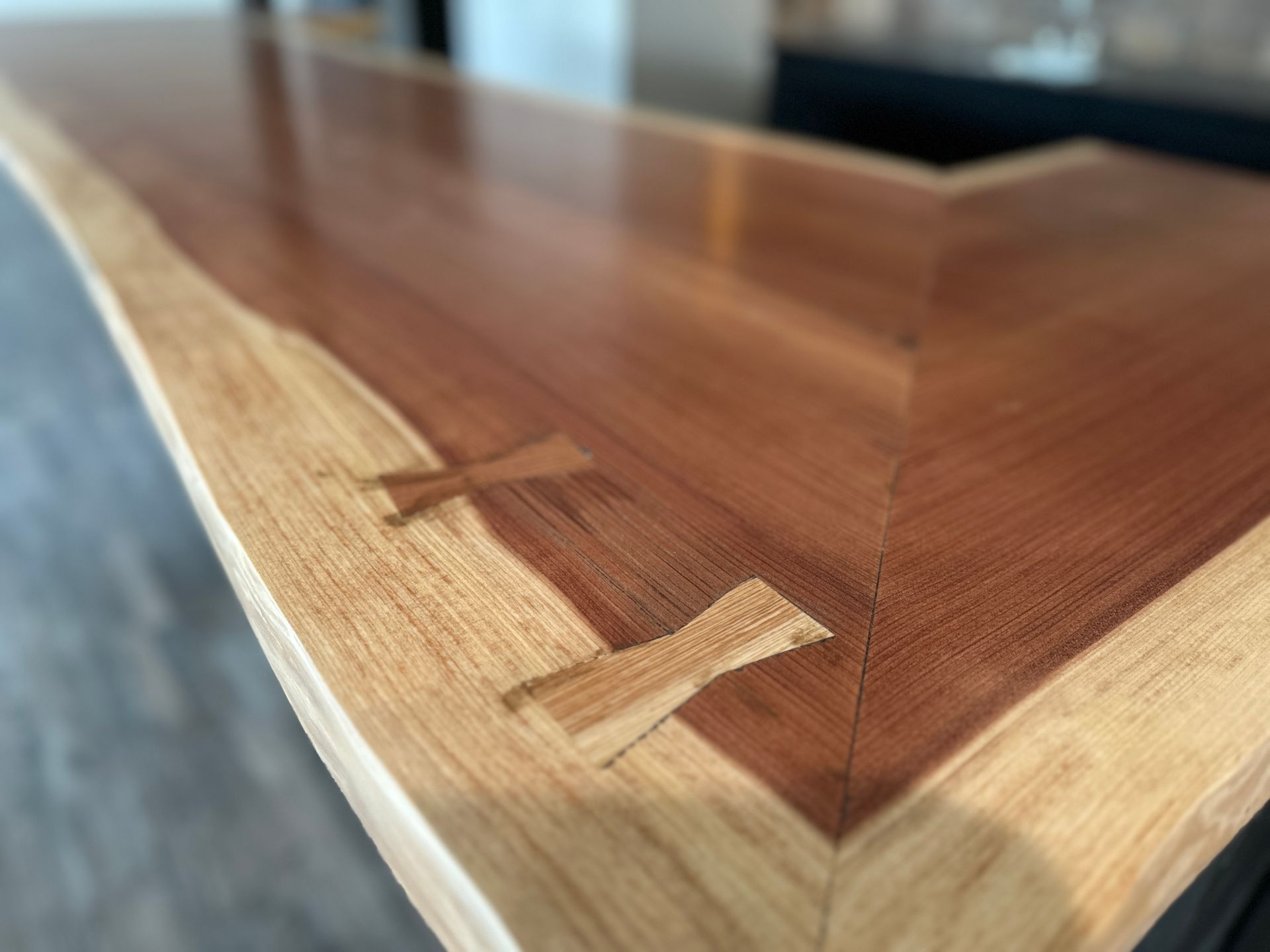 Wooden countertop with butterfly joints and live edge. Brown and tan colors, close-up shot.
