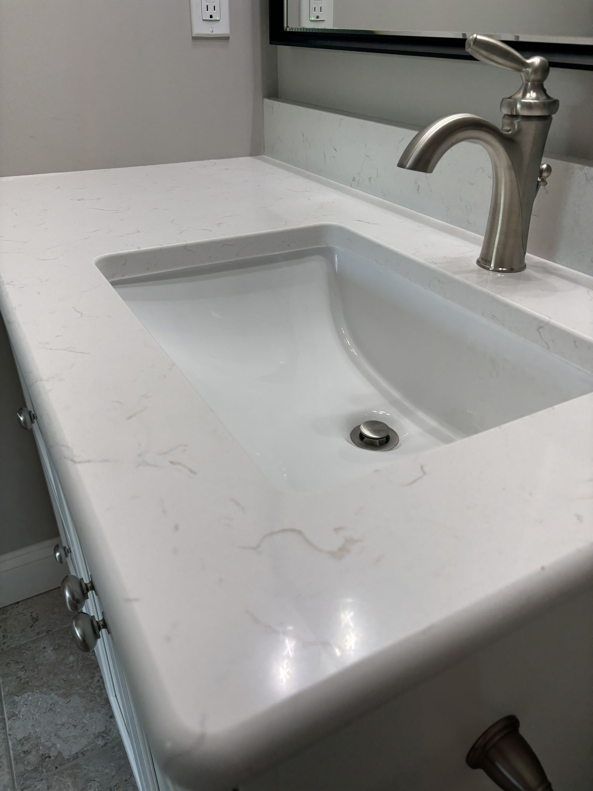 White bathroom sink with faucet on a countertop.