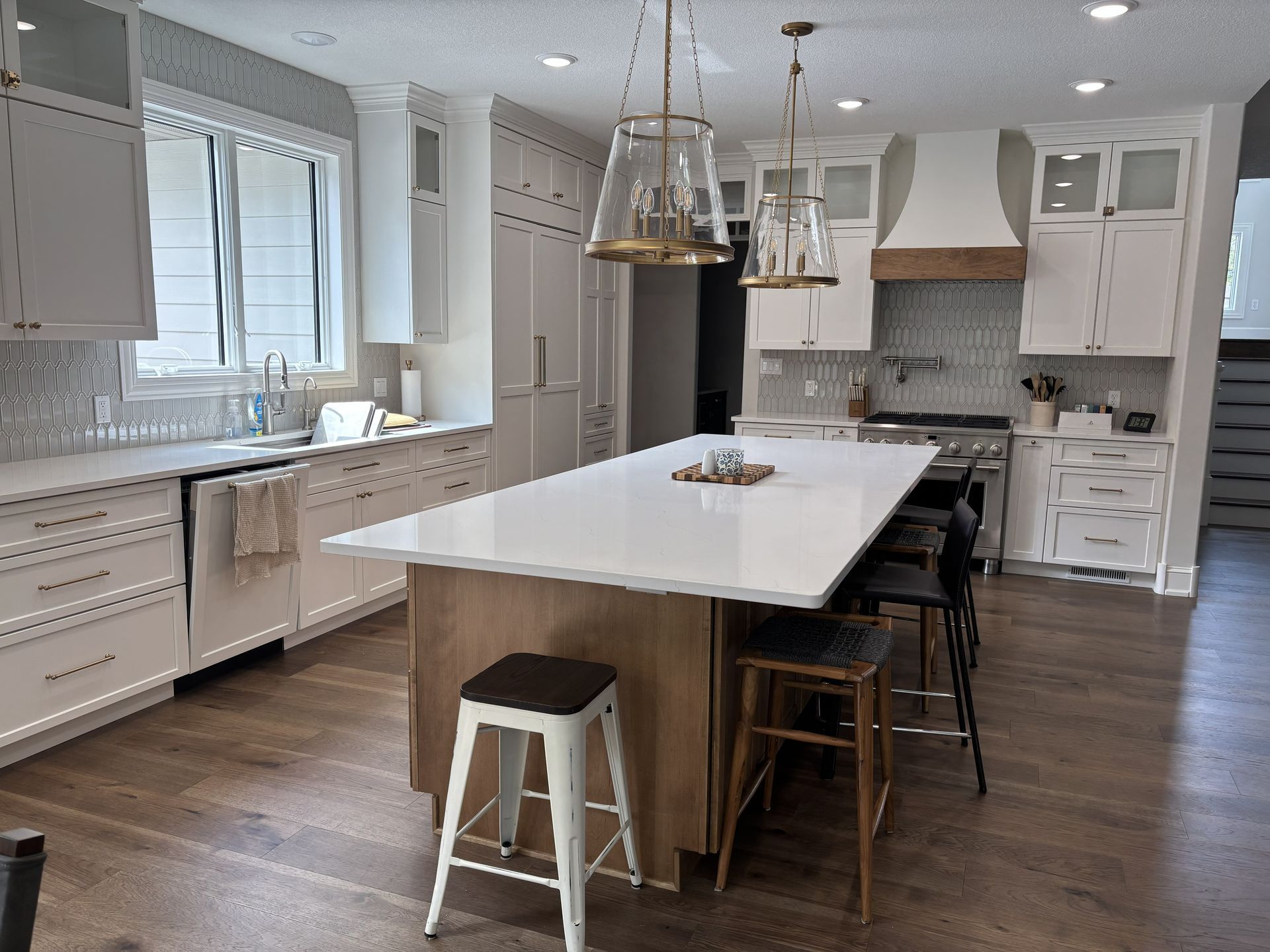 Modern kitchen with white cabinets, island, and stainless steel appliances.