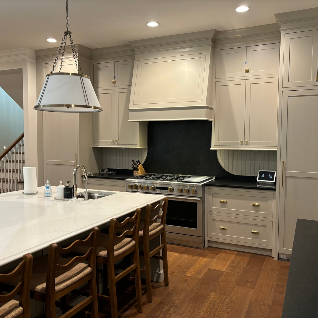 Kitchen with light-colored cabinets, stainless steel appliances, and a large island with seating.