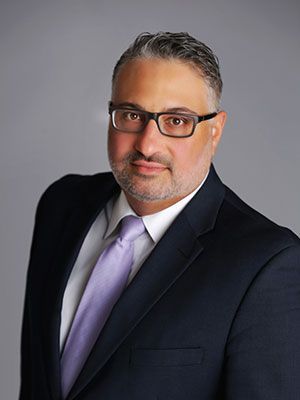 A man in a suit and tie is wearing glasses.
