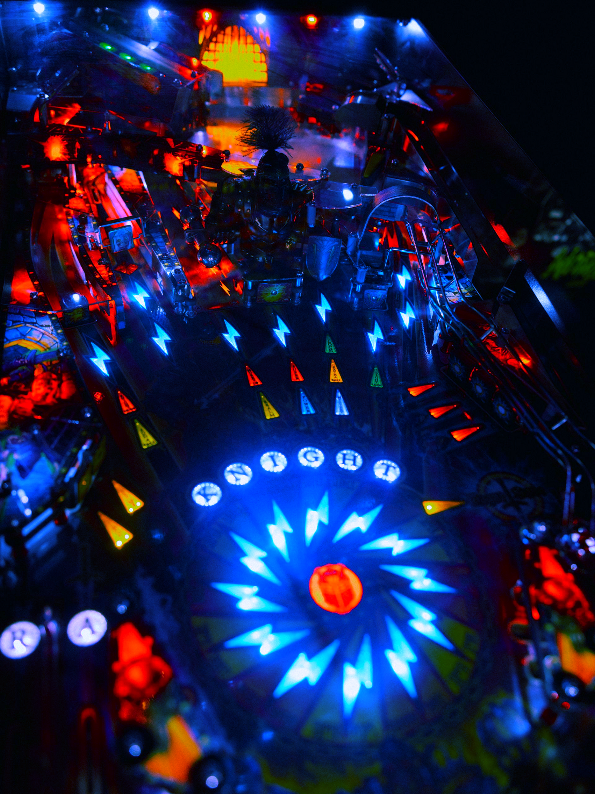 Retro pinball machine glowing with blue lightning bolt lights at GRID Arcade in Pleasant Grove Utah