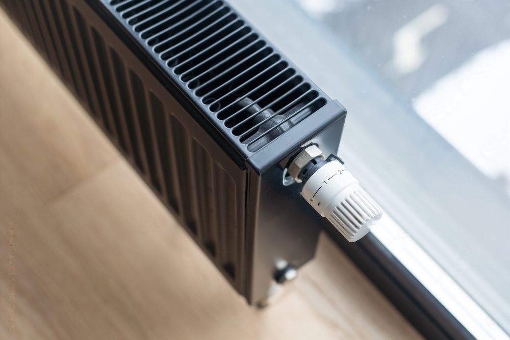 Een witte radiator staat op een metalen tafel.