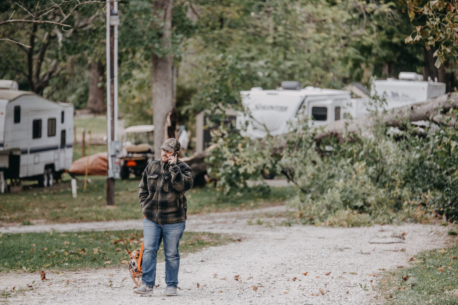 Man calls for help after a storm knocks down a large tree near trailers.