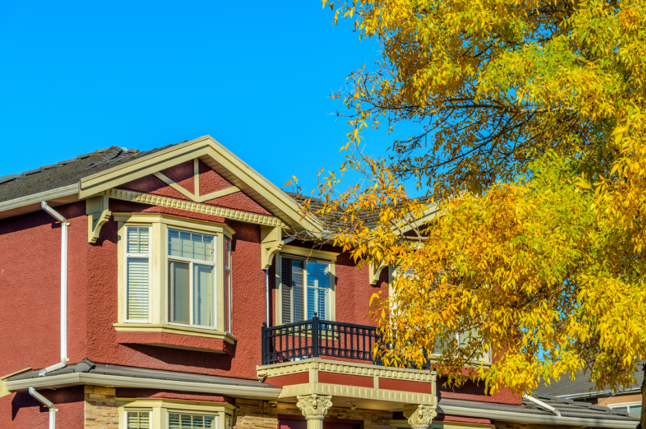 Well-maintained home exterior in summer with trees and clear weather, representing seasonal upkeep