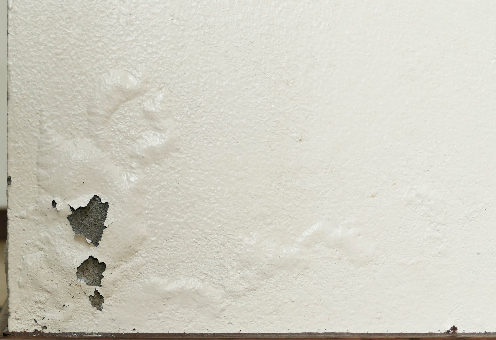Peinture qui pèle et cloques d'humidité sur un mur endommagé