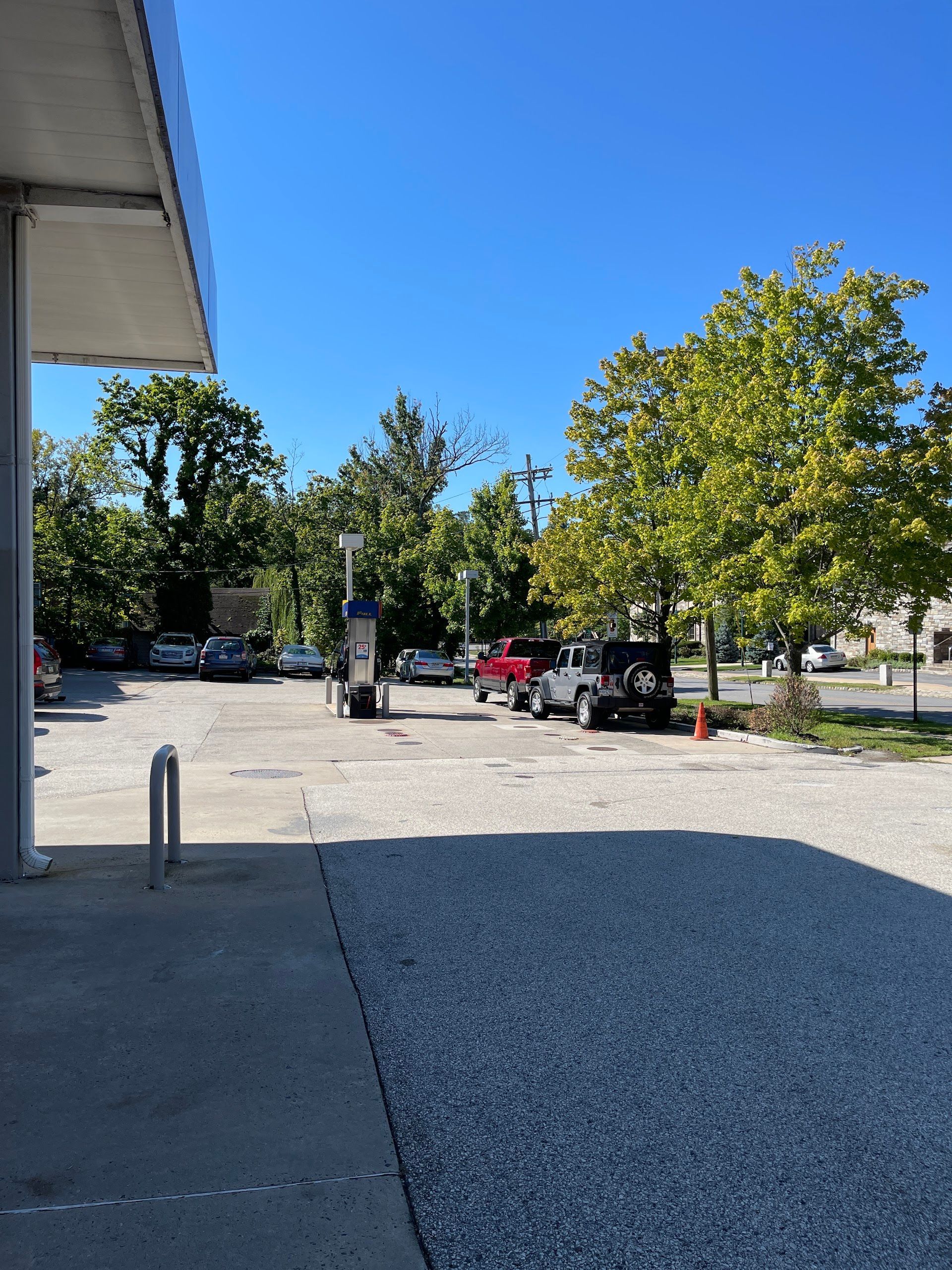 Gas station exterior with cars parked, trees, and a blue sky. | Aberdeen Automotive