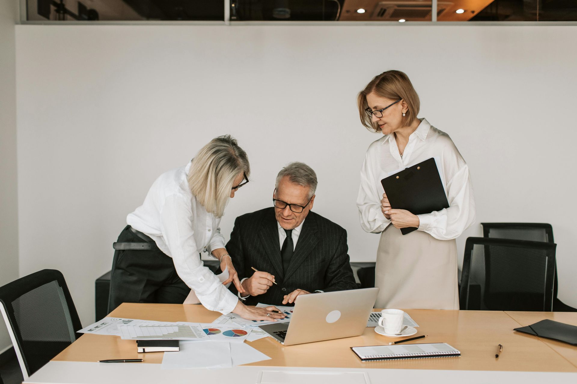 Three business people discuss financials.