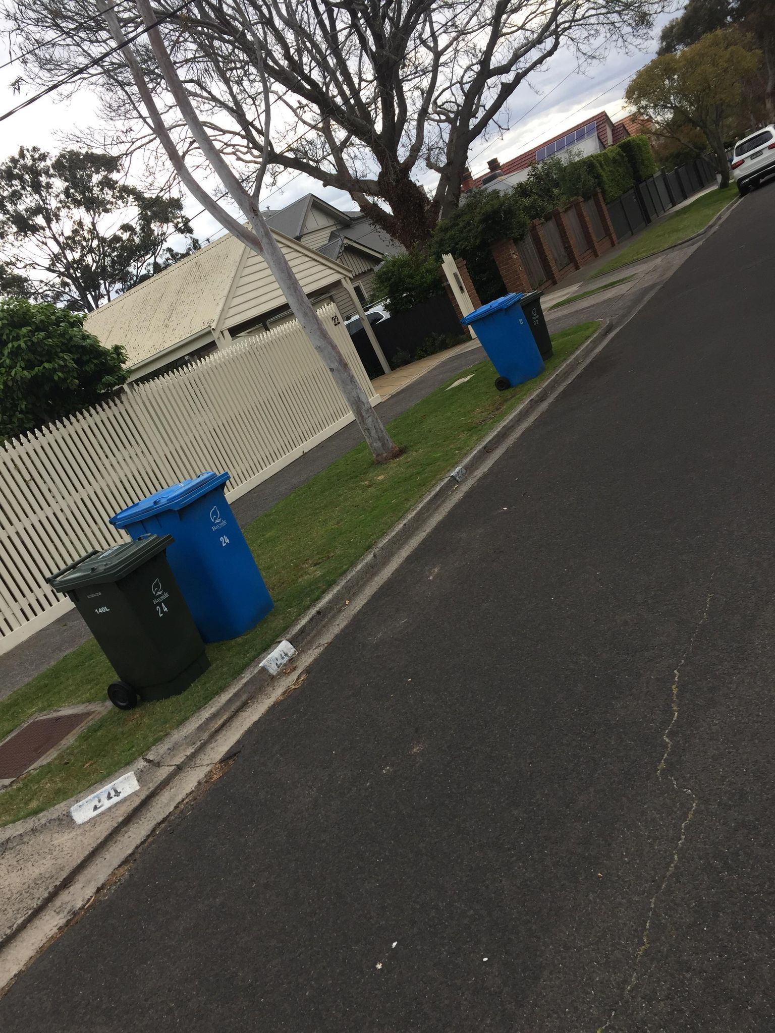 Blue wheelie bins placed at the kerb as part of Caddy Bins bin placement service