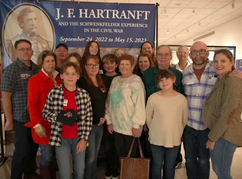 Group of people posing at a scholarship reception banner for J. F. Hartranft and the Scowheganon Club