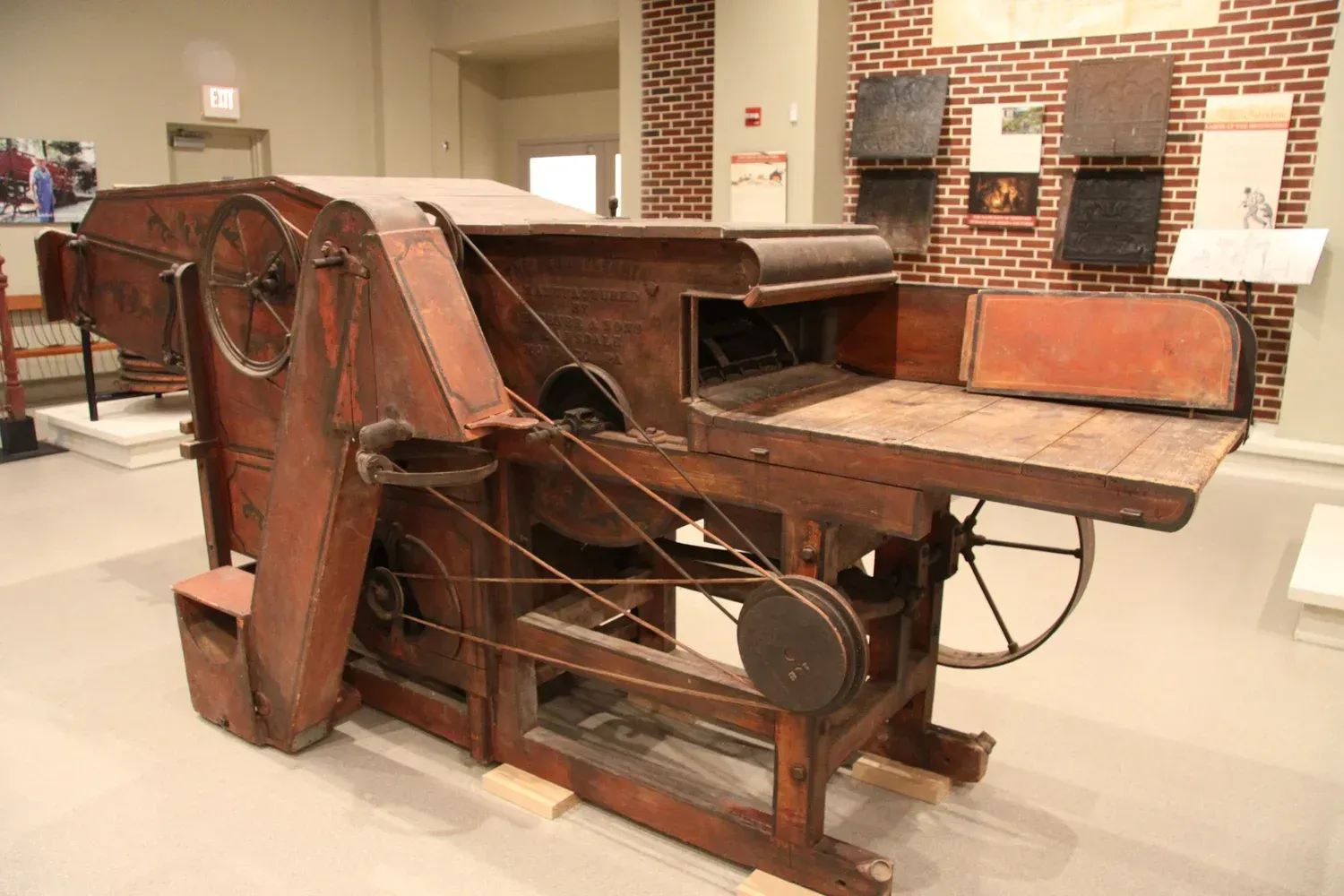 Antique wooden industrial machine displayed in a museum exhibit room