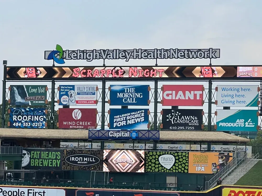 Billboard above stadium with Lehigh Valley Health Network, sports night, and multiple sponsor ads