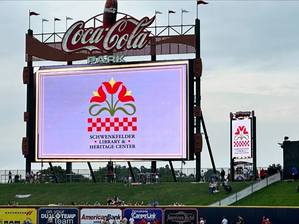 Coca-Cola stadium scoreboard showing a colorful logo and checkerboard display at a sports venue