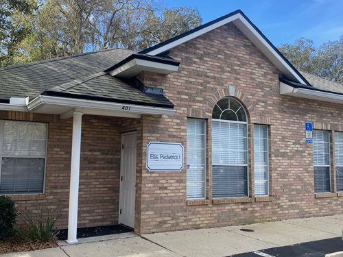 Brick office building entrance with a sign reading “City Pediatrics” and a covered porch.