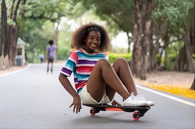 Person smiling while riding a skateboard on a tree-lined road