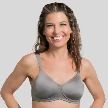 Smiling woman in a gray sports bra on a light background
