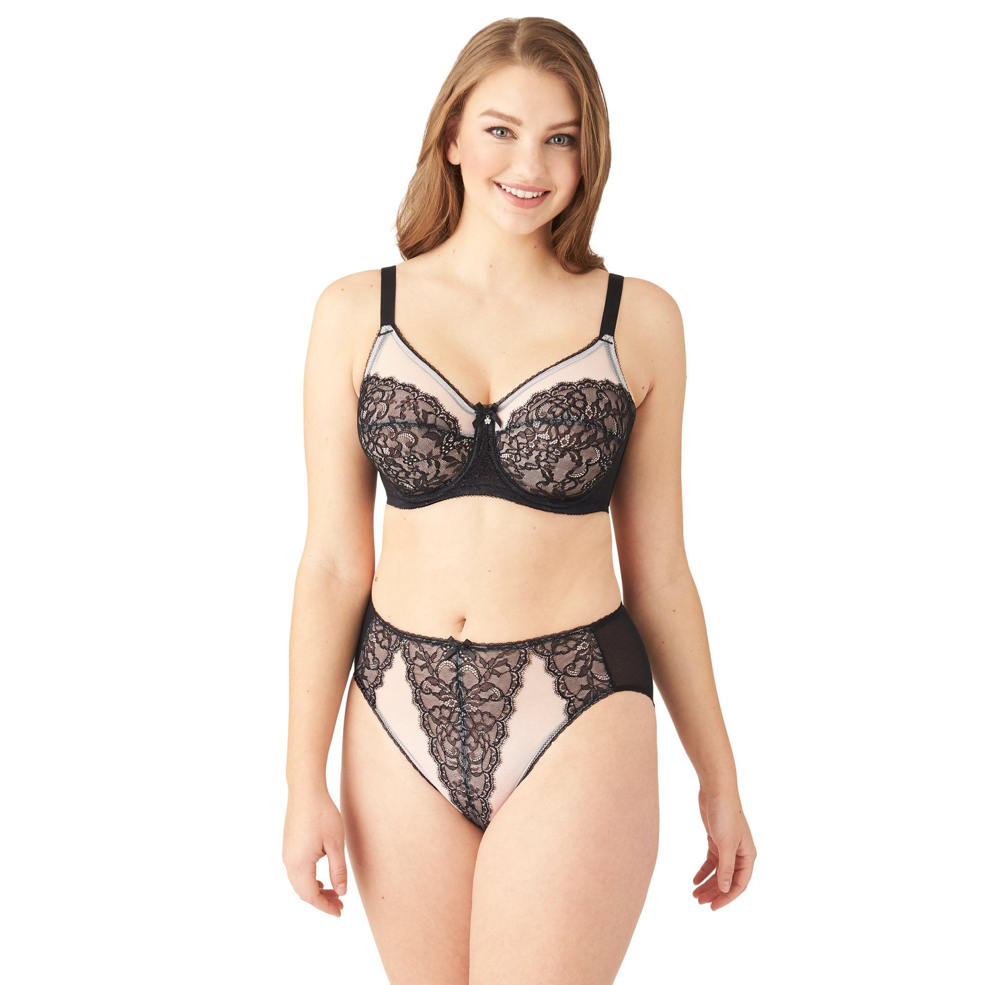 Woman modeling black lace lingerie on a white background