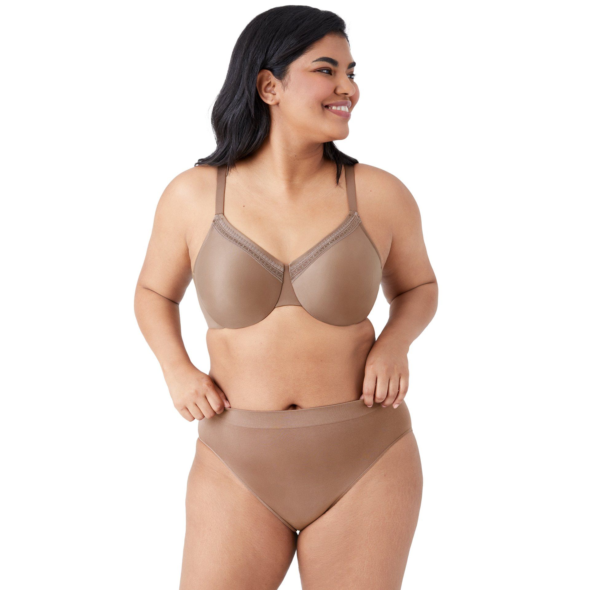 Woman in beige lingerie smiling and posing against a white background