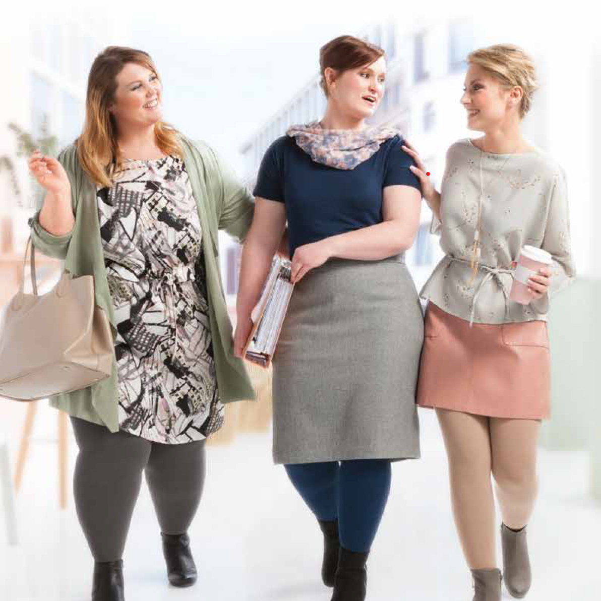 Three women walking together, modeling pastel and patterned spring outfits.