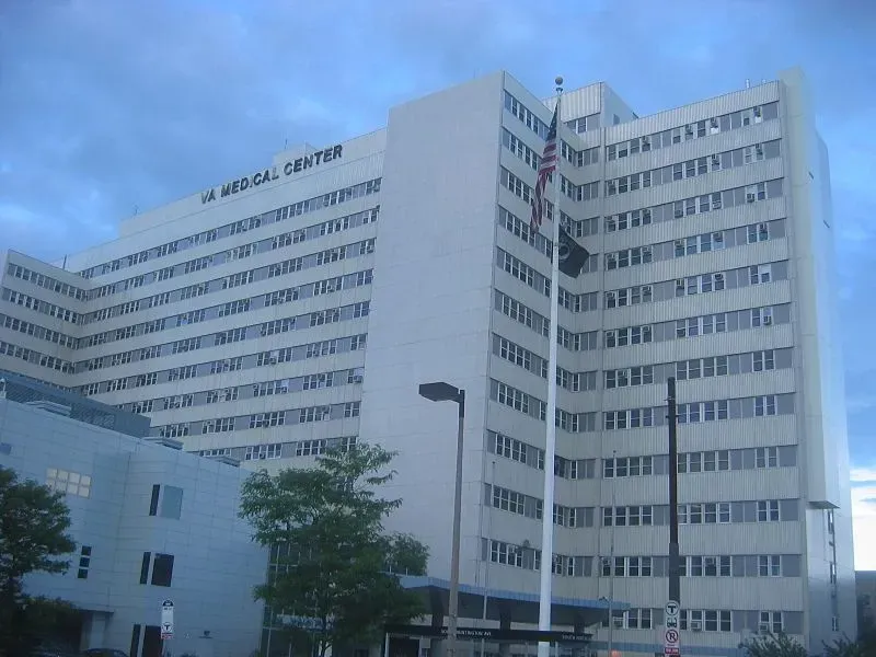 Large white hospital building with many windows against a blue sky