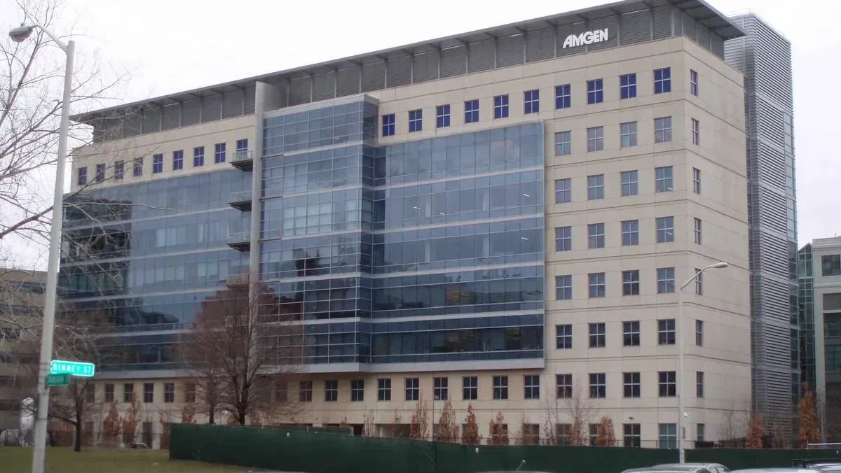 Large modern office building with glass façade and beige stone exterior on a city street