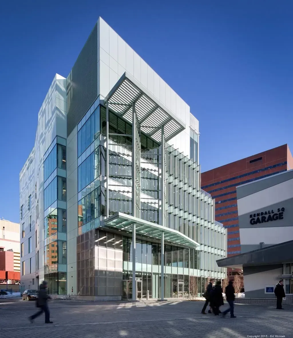 Modern glass office building with pedestrians on a sunny city street