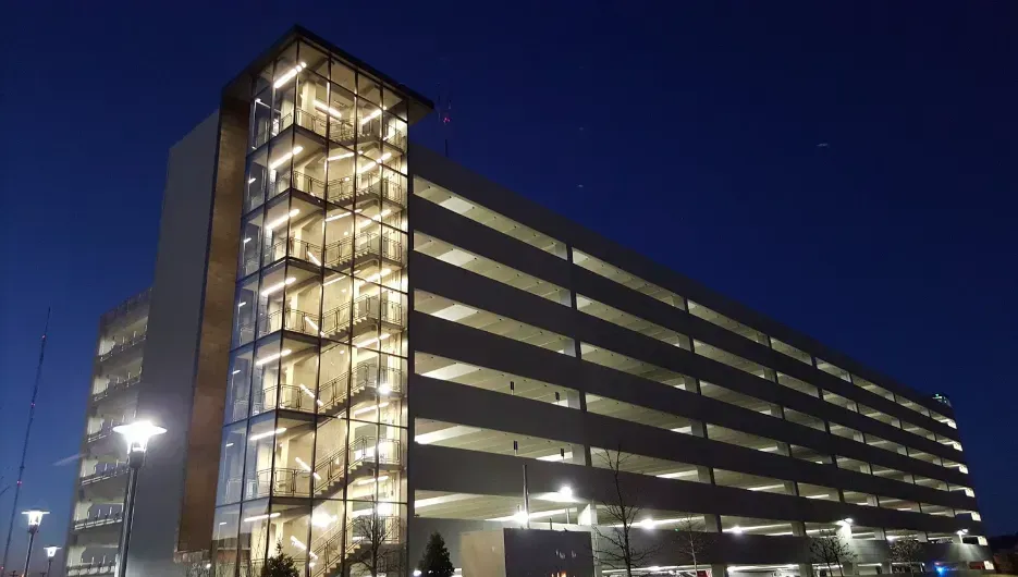 Nighttime view of a lit multi-story parking garage against a dark blue sky