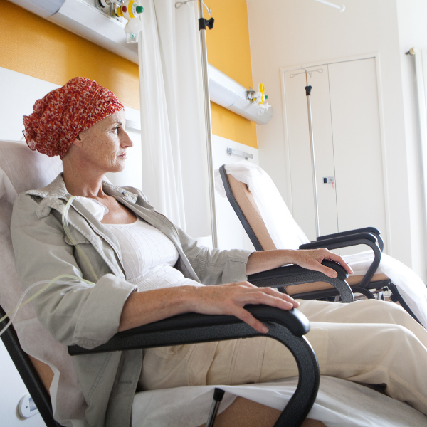 A woman wearing a head scarf is sitting in a hospital chair