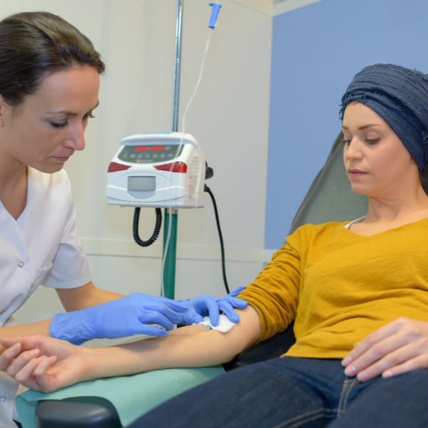 A woman in a yellow shirt is getting an injection from a nurse