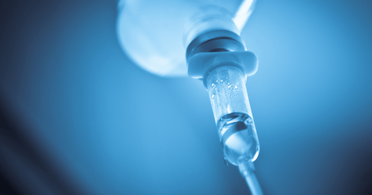 A close up of a syringe with a drop of liquid coming out of it.