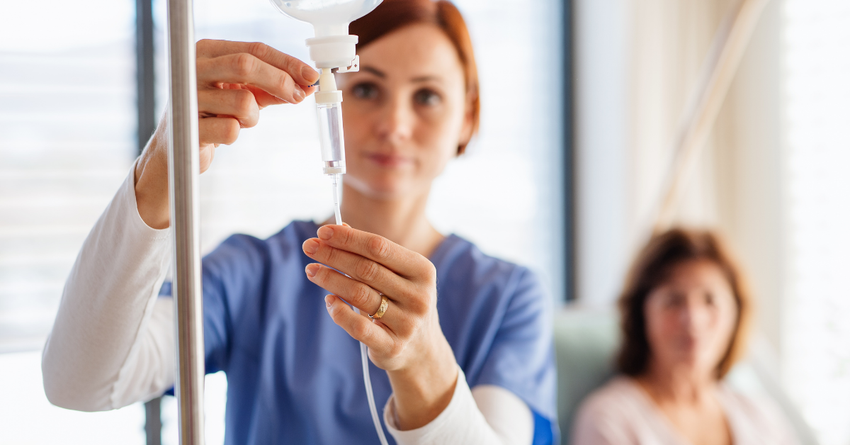 A nurse is preparing an iv for a patient in a hospital room.