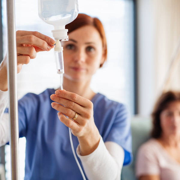 A nurse is preparing an iv for a patient in a hospital room.