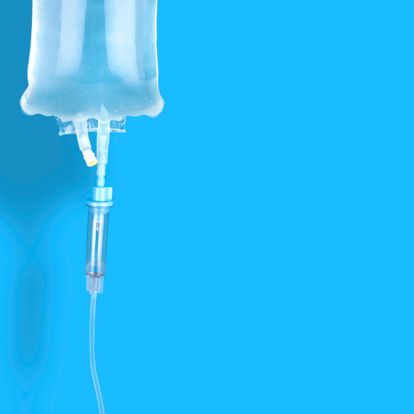 A bag of liquid is hanging from a hose on a blue background.