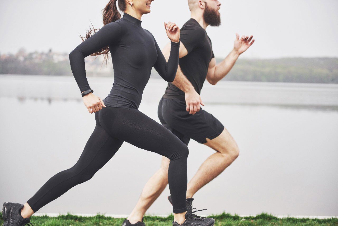 A man and a woman are running next to each other.
