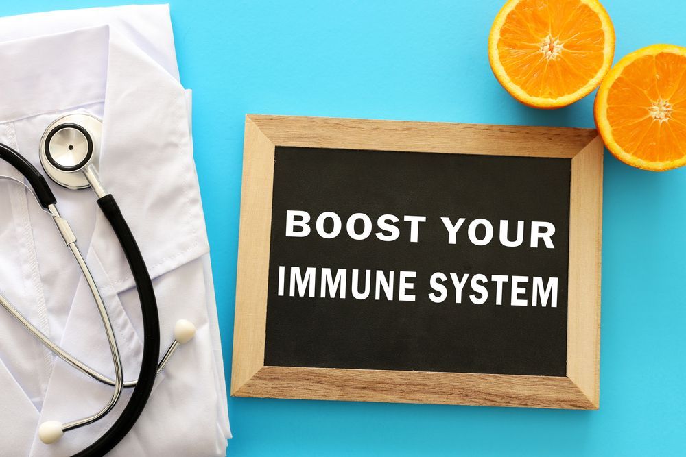 A blackboard with the words `` boost your immune system '' written on it next to a stethoscope and oranges.