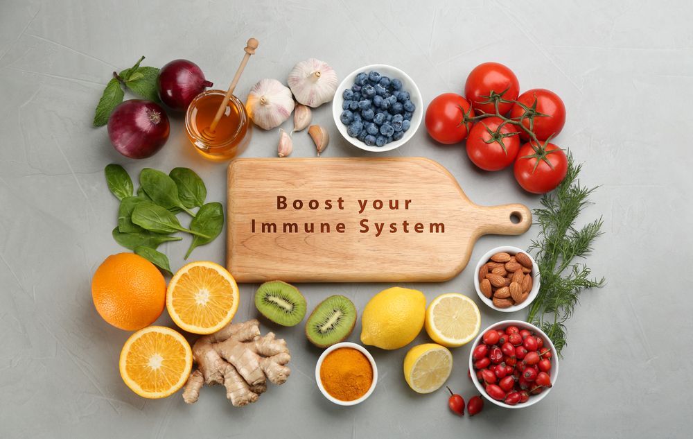 A wooden cutting board surrounded by fruits and vegetables with the words `` boost your immune system '' written on it.