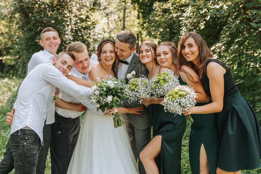 A bride and groom are posing for a picture with their wedding party.